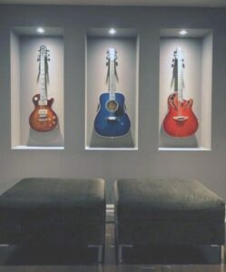 Guitars mounted in lit built-in wall niches in a finished basement