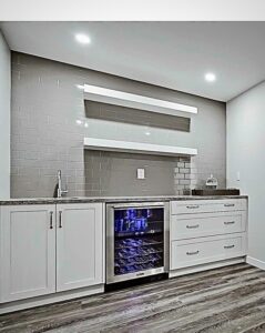 Basement wet bar with stone counter, wine fridge and tiled backsplash