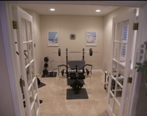 Home gym behind French doors in a finished basement
