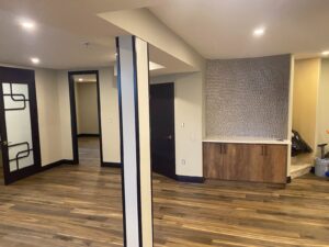 Finished basement with hardwood floor, feature wall and pot lights