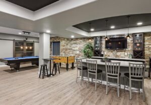 Basement games room with bar seating, pool table and stone feature wall