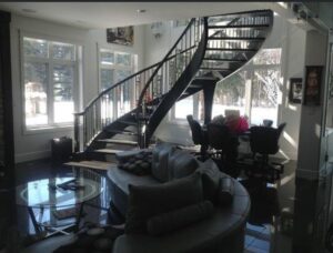 Open living room with curved staircase and large windows